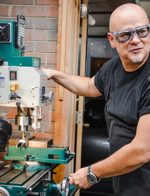 Jeff using the drill press in his machine shop to make tooling for inawehandmade