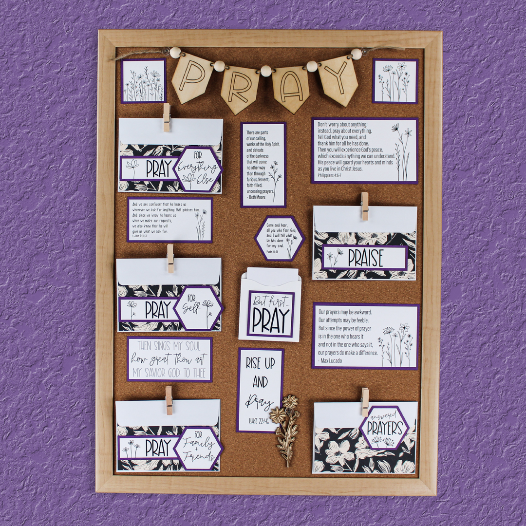 Prayer board featuring black floral paper with purple accents and wildflower graphics along with a PRAY banner for prayer corner.