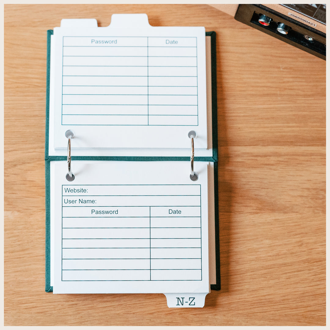 Open internet password book showing website and username fields, with lines for passwords and dates on the front and back of each card.