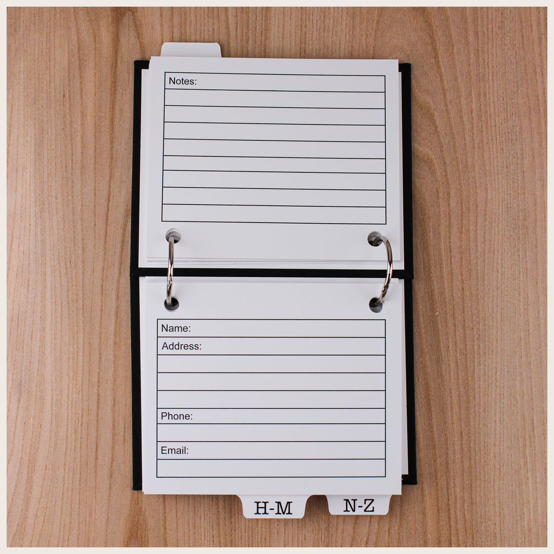 Open address book showing contact cards with fields for name, address, phone, and email, plus lined notes on the back.