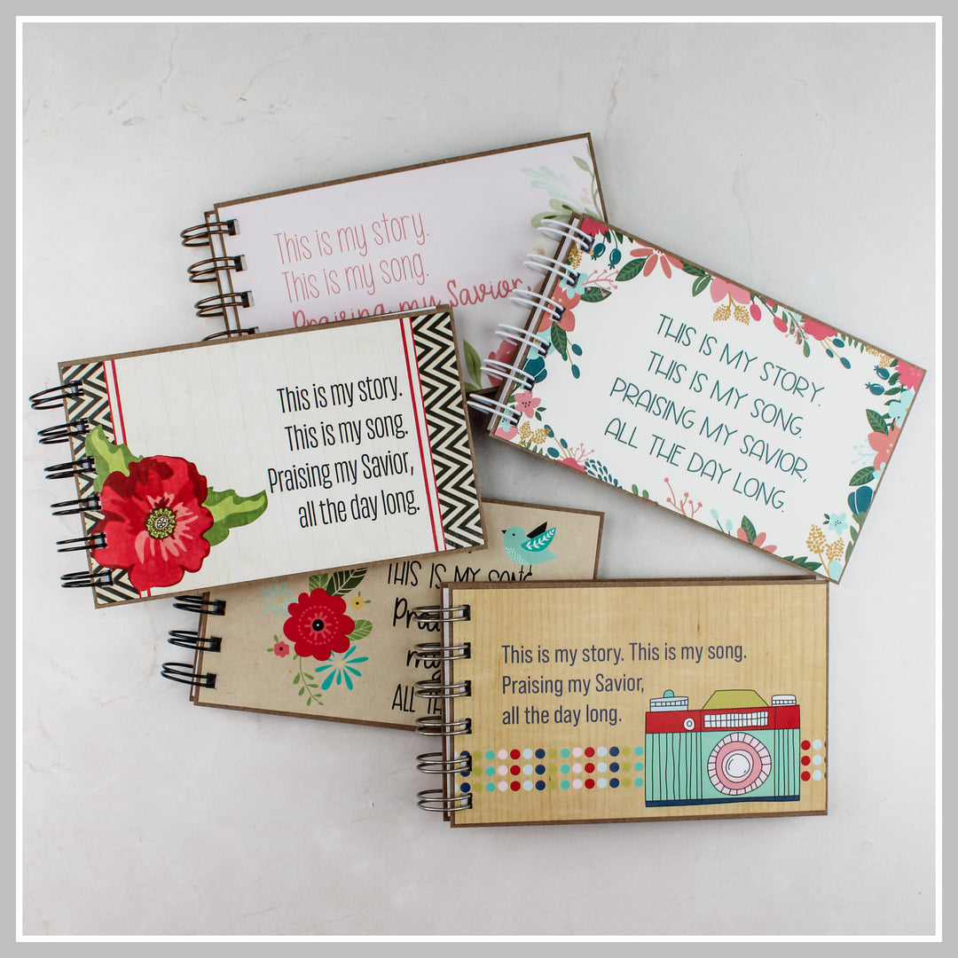 Assorted Christian prayer journals in bulk featuring multiple 4P journal styles, including floral, botanical, bluebird, and camera designs.