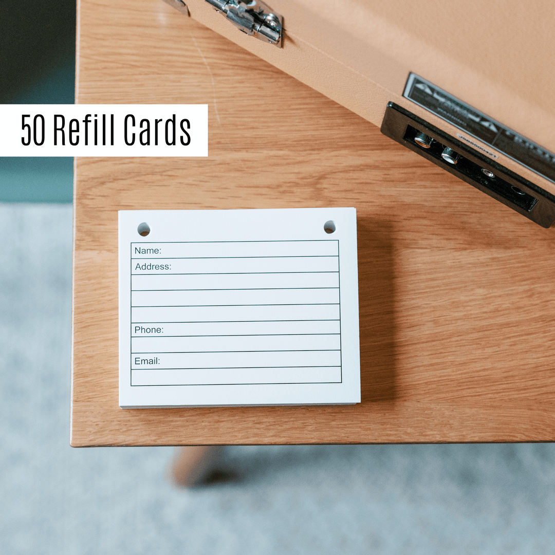 50 address book refill cards with name, address, phone, and email fields on a wooden surface.
