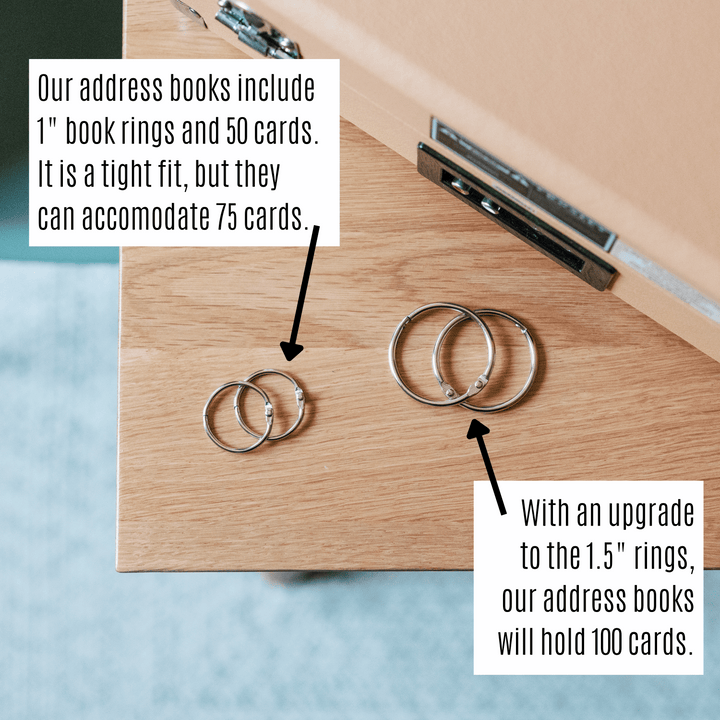 Address book rings on a wooden surface with text describing their capacity.
