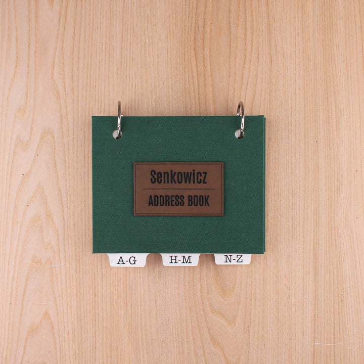 Dark green small address book with dark brown leatherette title "Senkowicz ADDRESS BOOK".