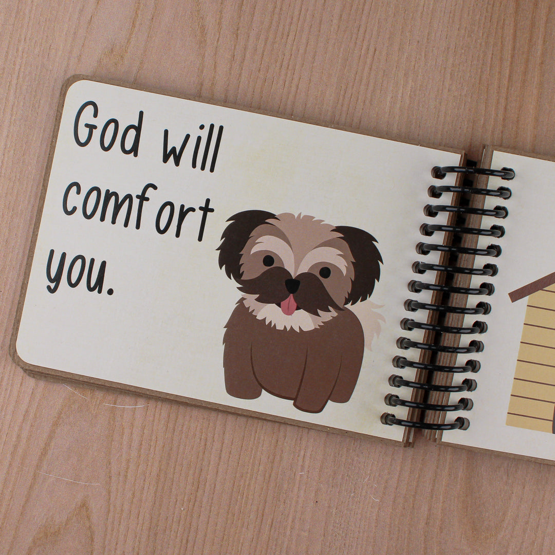 Close up of text 'God will comfort you' with brown dog graphic and details of coil binding.