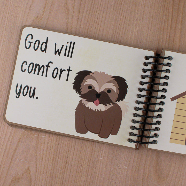 Close up of text 'God will comfort you' with brown dog graphic and details of coil binding.