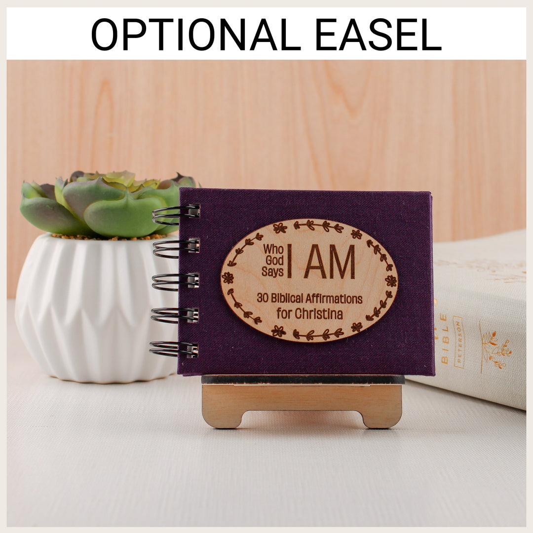 Plum affirmation book personalized for Christina displayed on an optional wood easel beside a succulent and Bible.