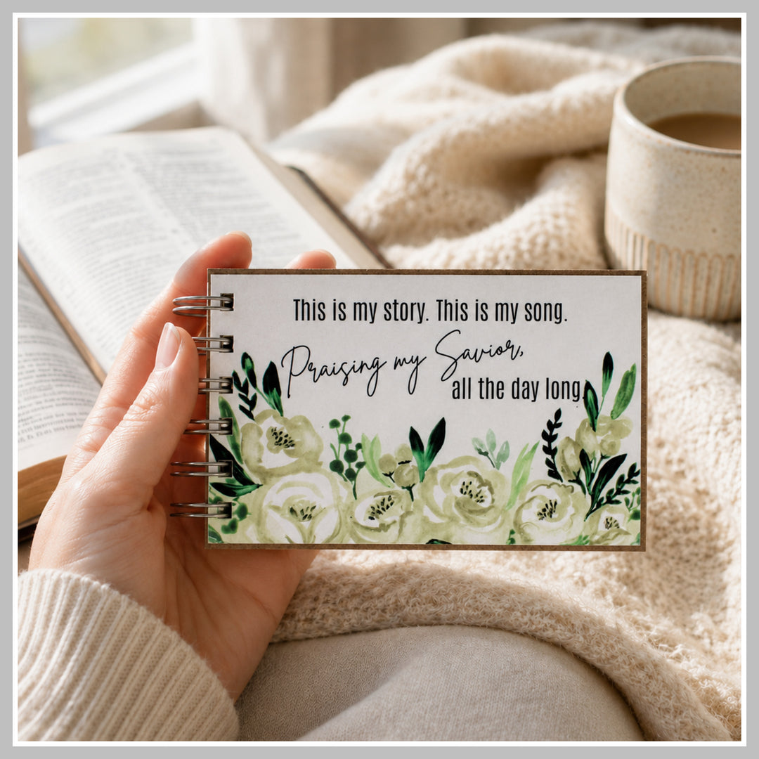 Botanical Christian prayer journal held in hand beside a Bible and coffee.
