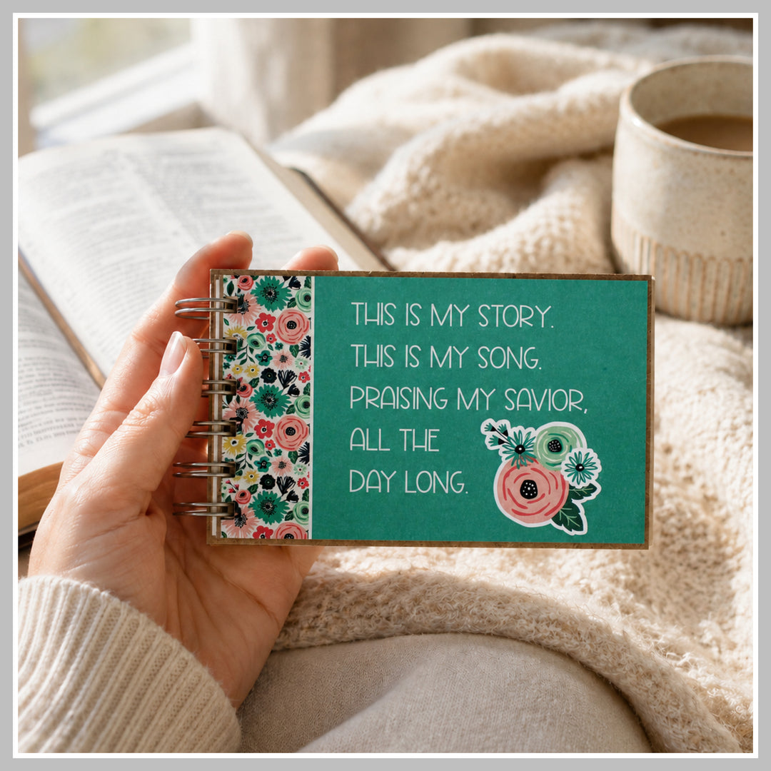 Teal Christian prayer journal held in hand beside a Bible and coffee.