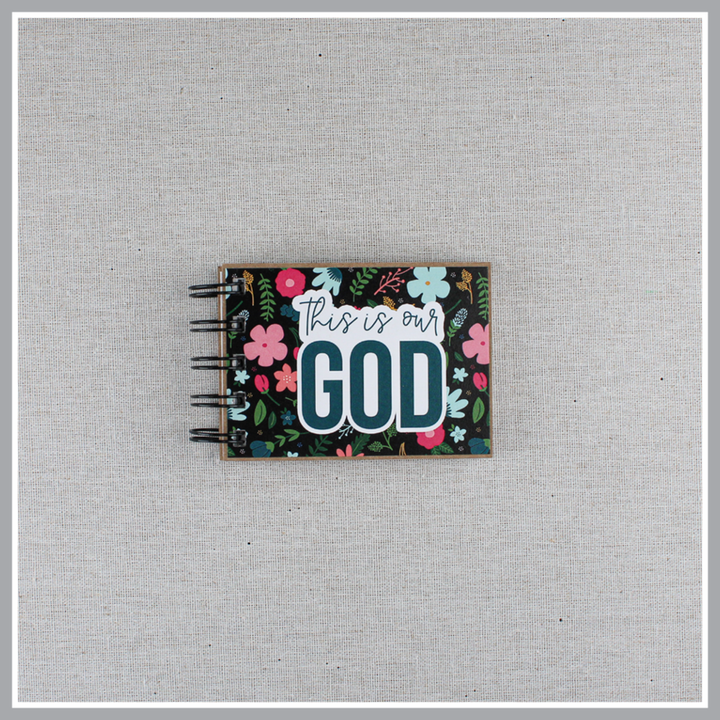 God's attributes book with black background and pastel florals. Text says 'this is our GOD'.