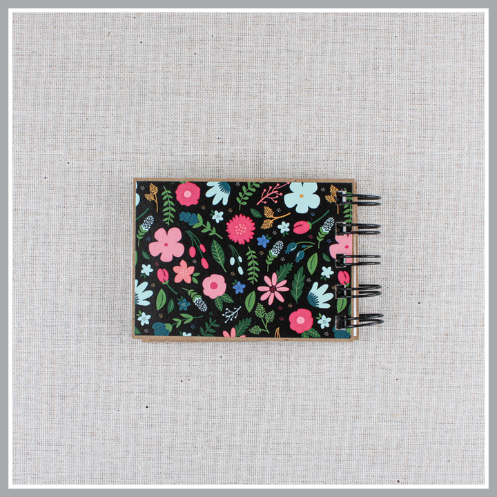 Back cover of God's attributes book with black background and pastel florals. Text says 'this is our GOD'.