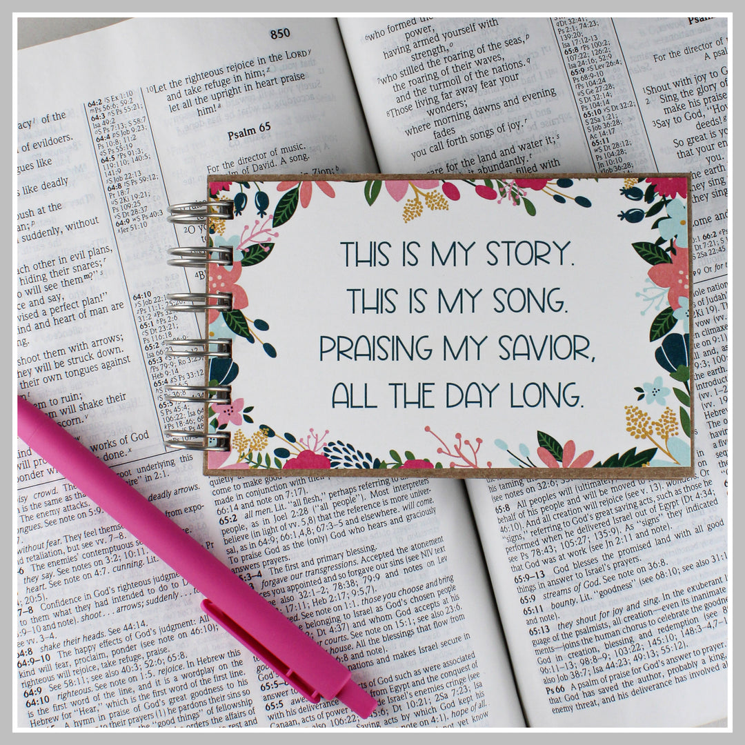 Flower frame Christian journal resting on an open Bible for prayer, gratitude and daily quiet time.