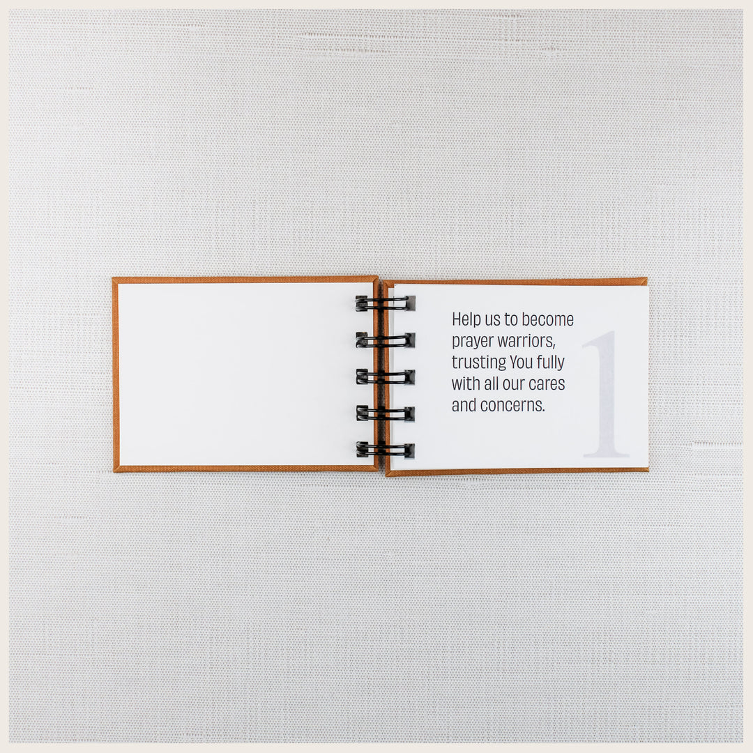 Family prayer book open to prayer 1, asking God to help us become prayer warriors and trust Him with our cares and concerns.