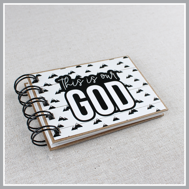 God's attribute book with 'This is our GOD' text on a light gray background  at an angle to show 3/8" thickness.