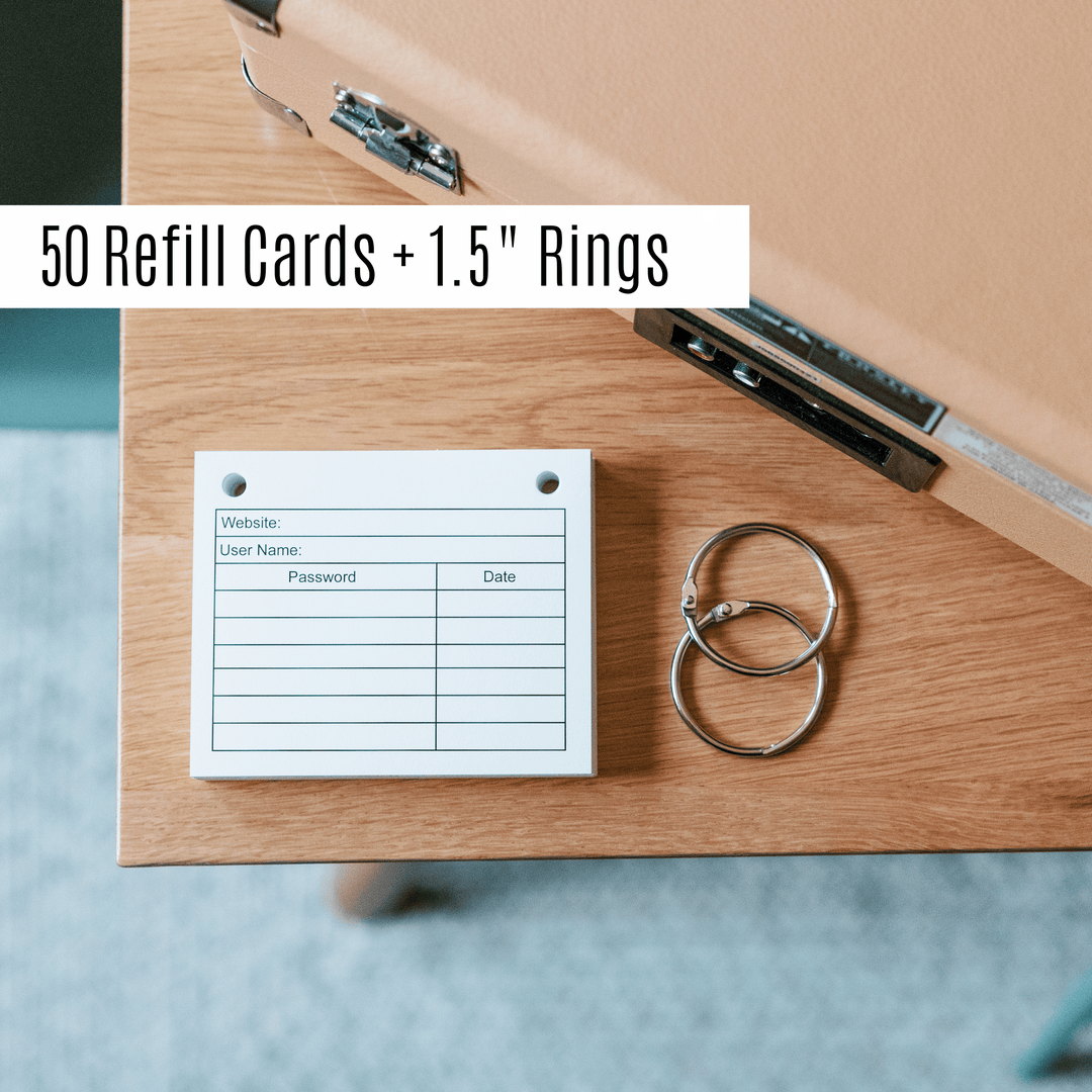 password book refill pages and 1.5" book rings on wood surface.