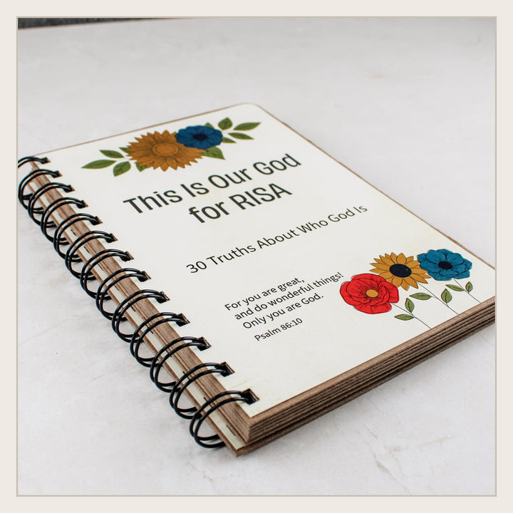 Angled view of handmade personalized Christian book with sturdy chipboard covers and black wire binding.