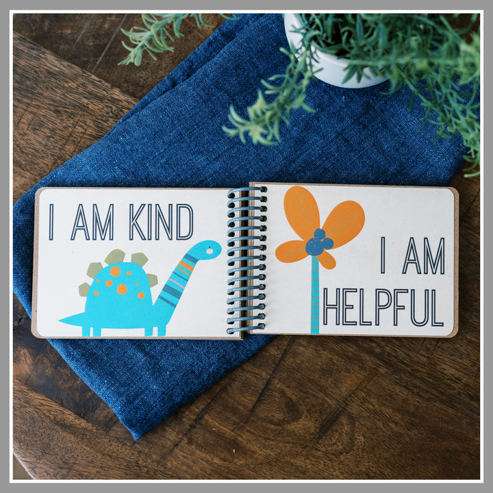 Open Dinosaur affirmation book showing “I am kind” and “I am helpful” pages with colorful dinosaurs.