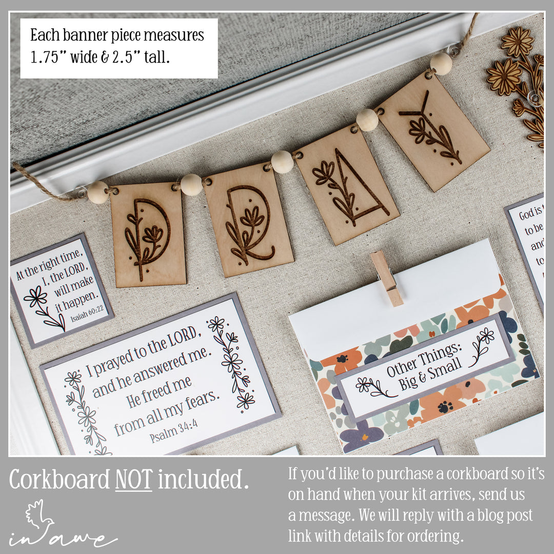 Decorative pray banner pieces with floral daisy designs and text on prayer board.