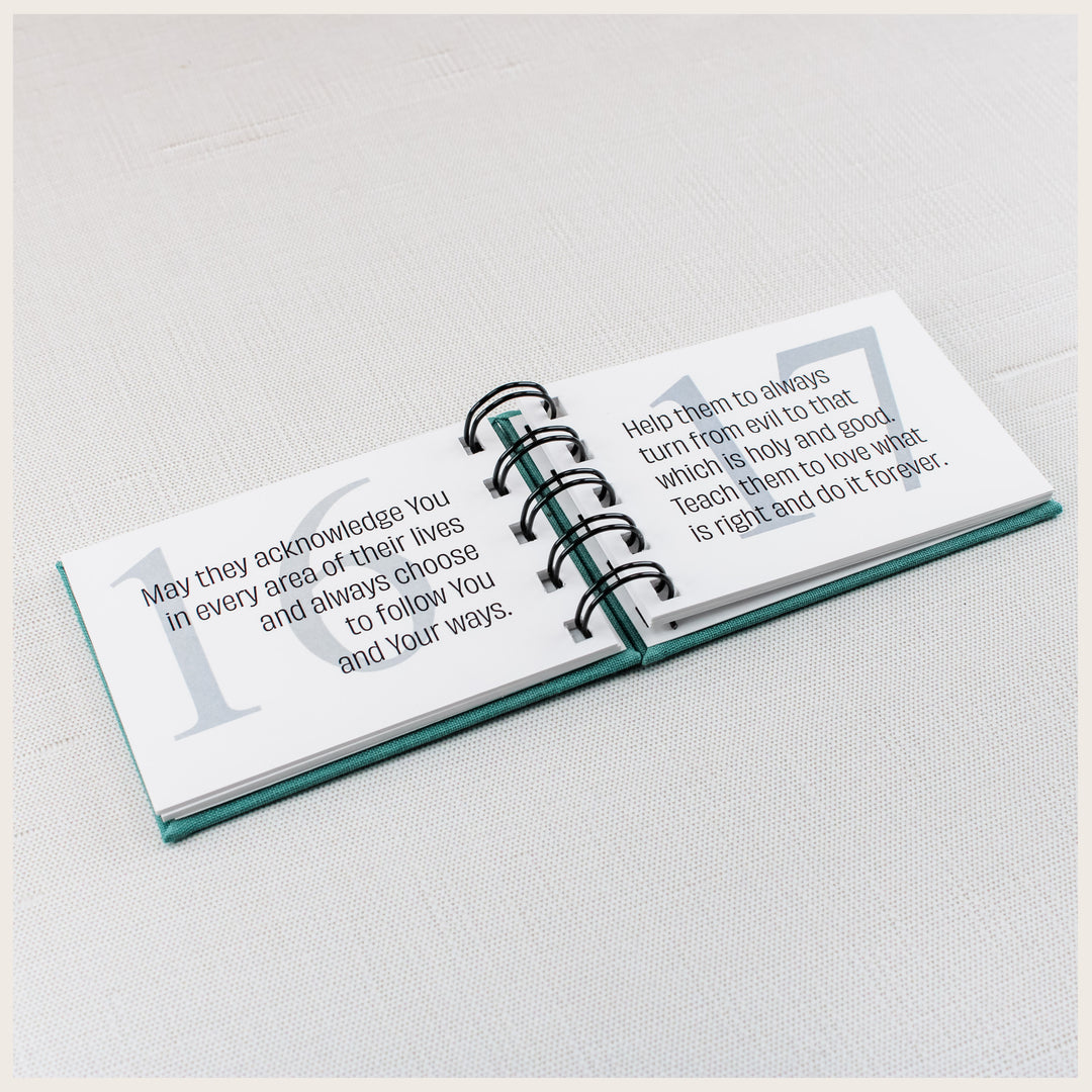 Teal spiral prayer book open to prayers 16 and 17 about following God, turning from evil and loving what is right.