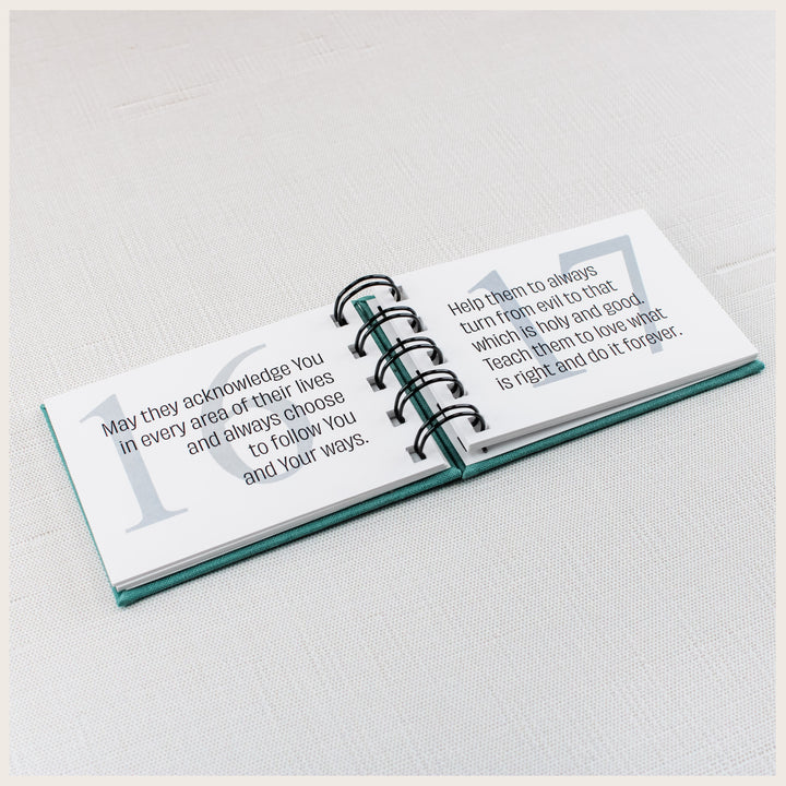 Teal spiral prayer book open to prayers 16 and 17 about following God, turning from evil and loving what is right.