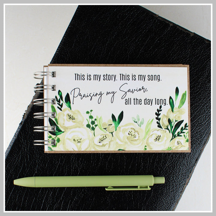 Botanical Christian journal resting on a Bible for prayer, gratitude and daily quiet time.
