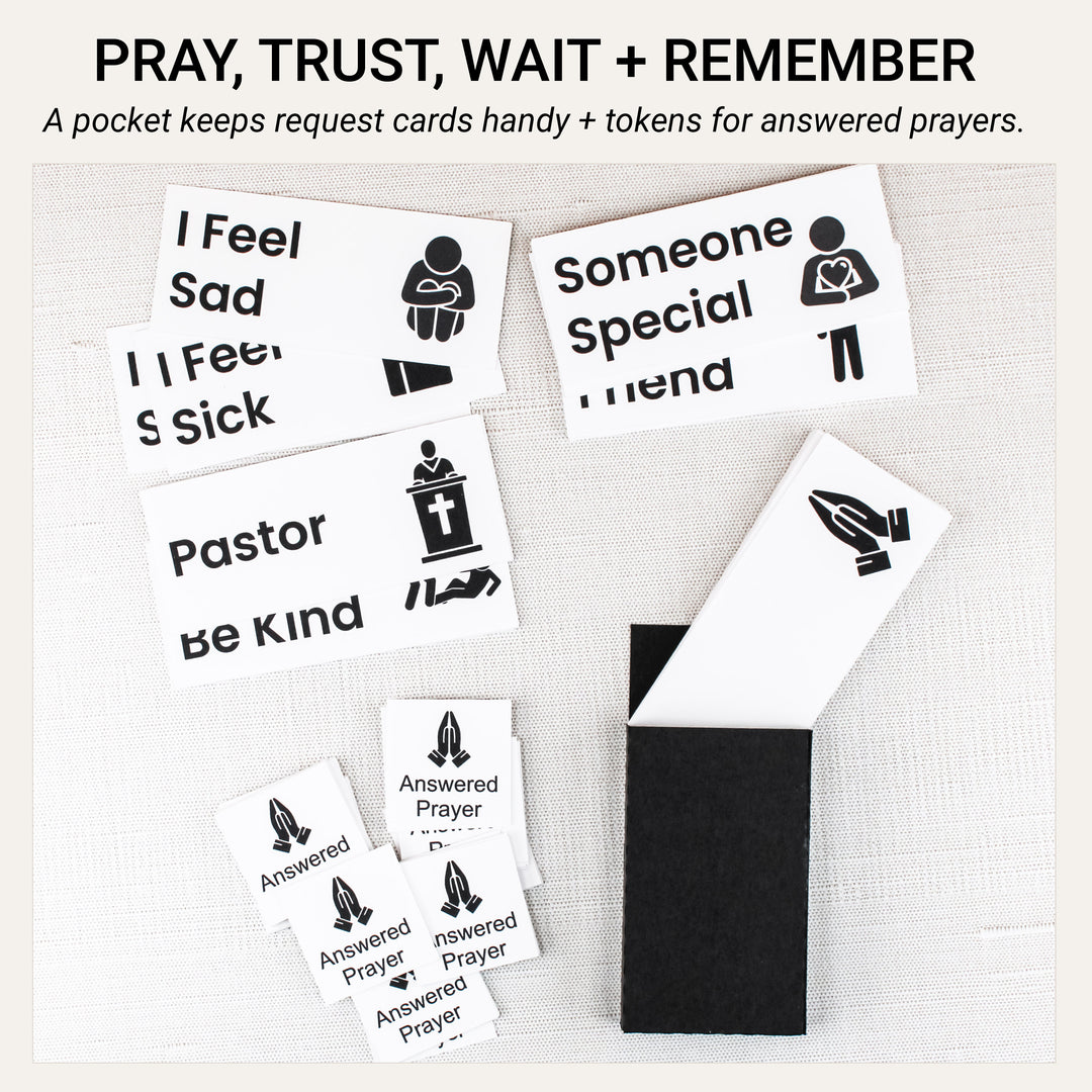 Handmade black pocket for prayer request cards beside illustrated request cards and answered prayer tokens with praying hands.