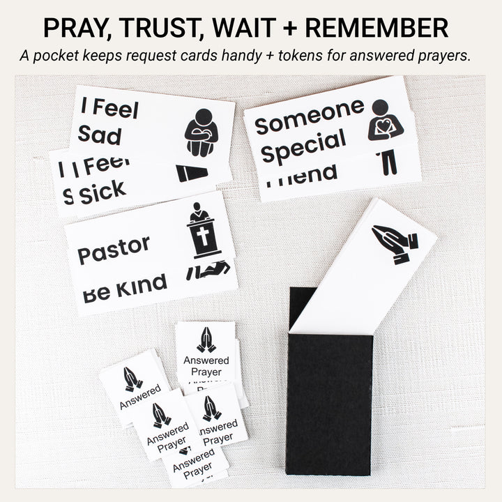 Handmade black pocket for prayer request cards beside illustrated request cards and answered prayer tokens with praying hands.
