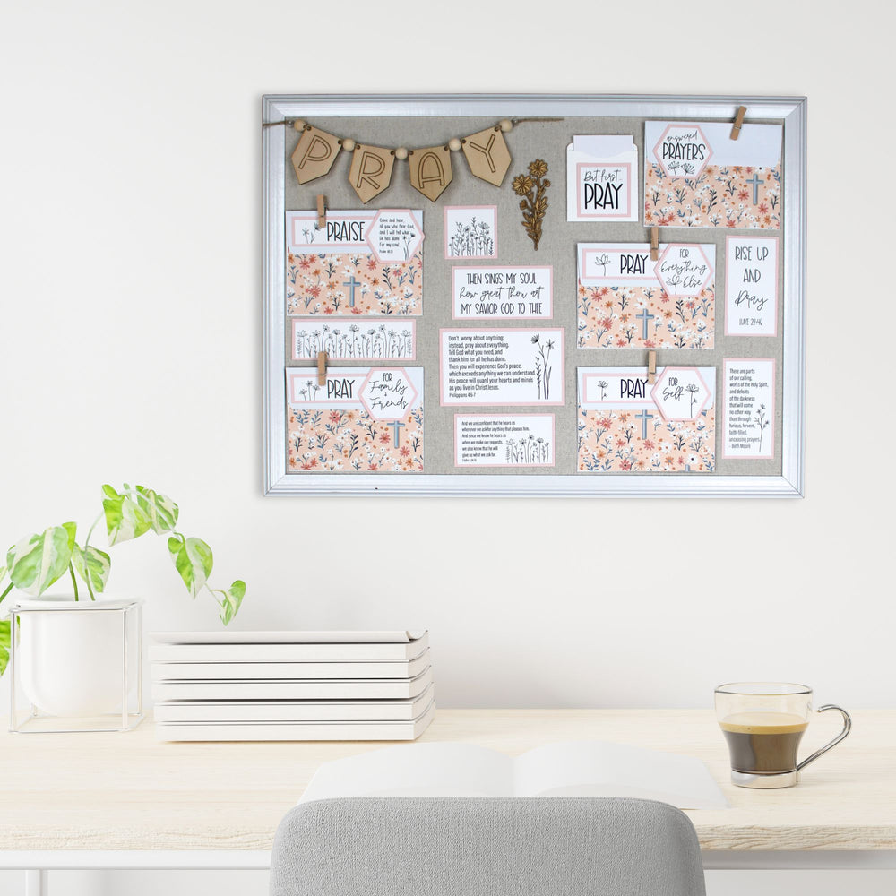 Pink prayer board on the wall above a desk.
