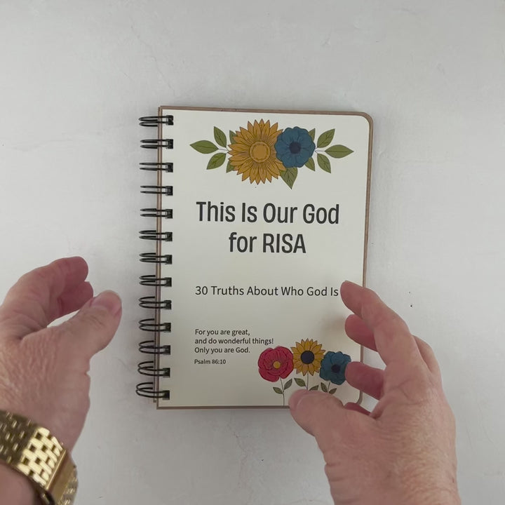 Hand flipping through personalized Christian book for kids ages 8 to 12 featuring 30 truths about the attributes of God.