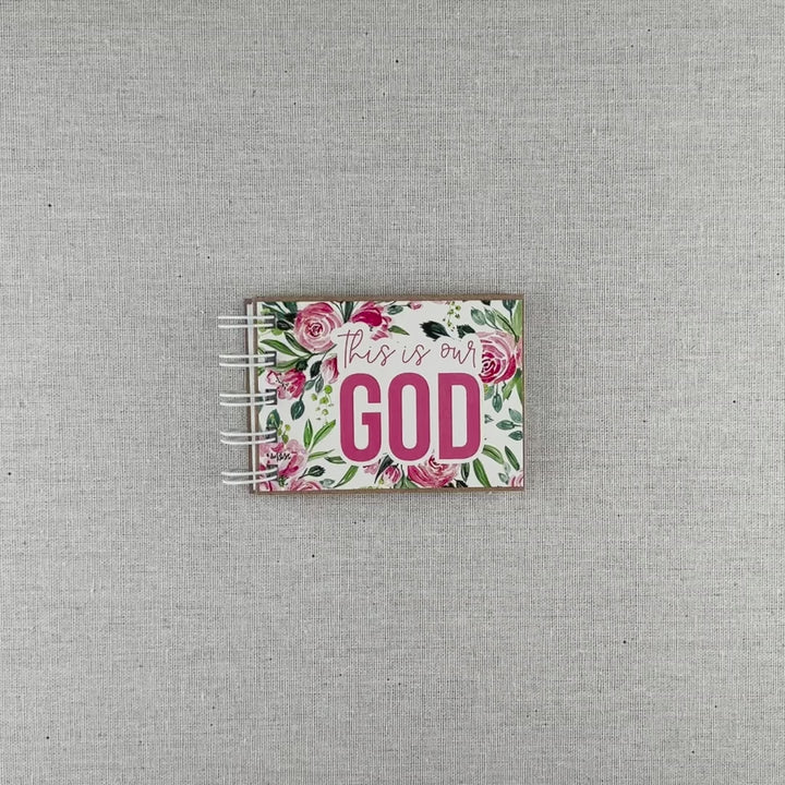 Video of attributes of God spiral bound book with pink flowers and green leaves. Front cover says "this is our GOD".