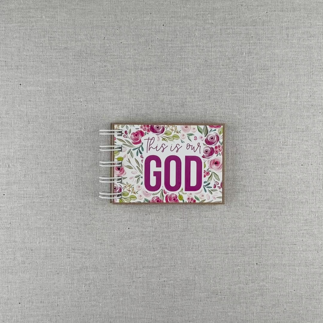 Video of God's attributes book spiral bound in Pastel Floral style with pink and purple floral background. Front cover says "this is our GOD".