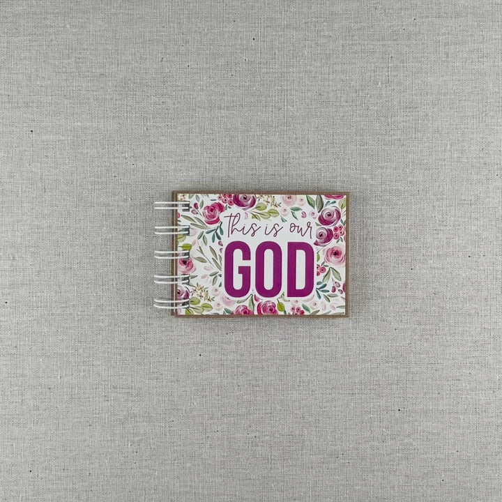 Video of God's attributes book spiral bound in Pastel Floral style with pink and purple floral background. Front cover says "this is our GOD".
