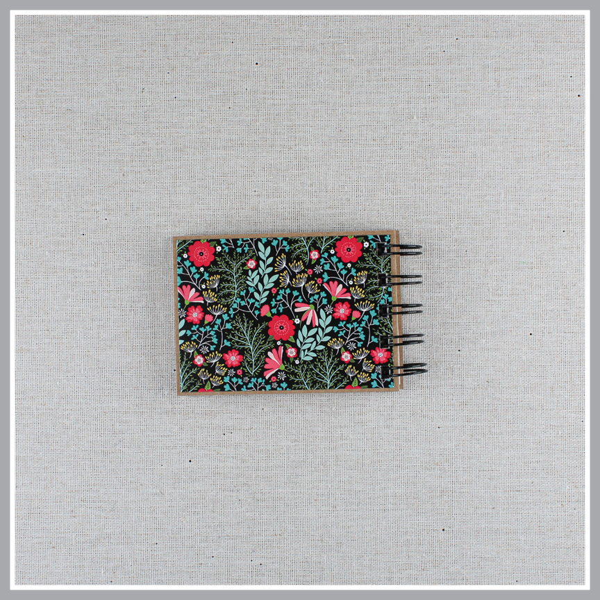 Back cover of God's attribute book with a black background and bright florals. The cover of this small, spiral-bound book says "this is our GOD".