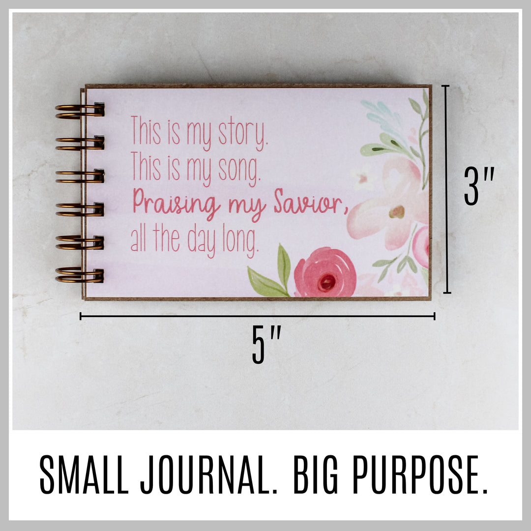 Pink floral Christian journal showing its compact 5 by 3 inch size.