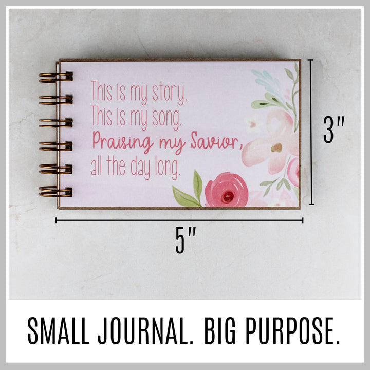 Pink floral Christian journal showing its compact 5 by 3 inch size.