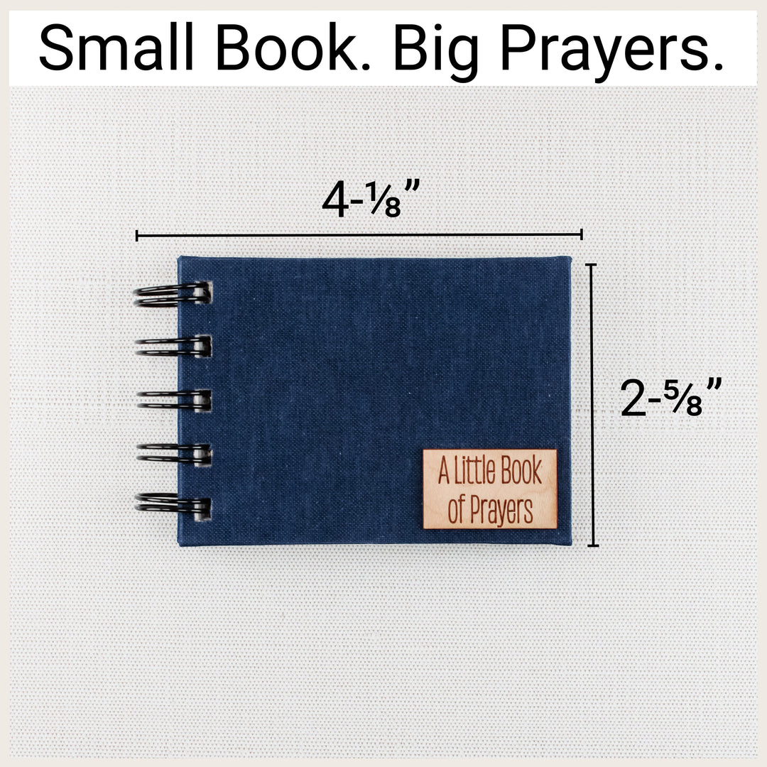 Navy spiral prayer book with size labels showing 4⅛ inches wide, including binding, and 2⅝ inches tall.