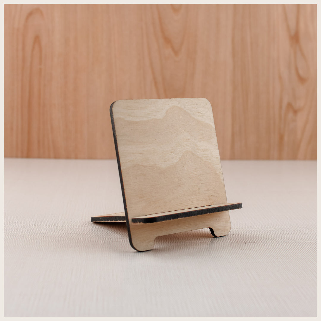 Small natural wood easel with rounded corners and a front ledge for displaying mini spiral books.