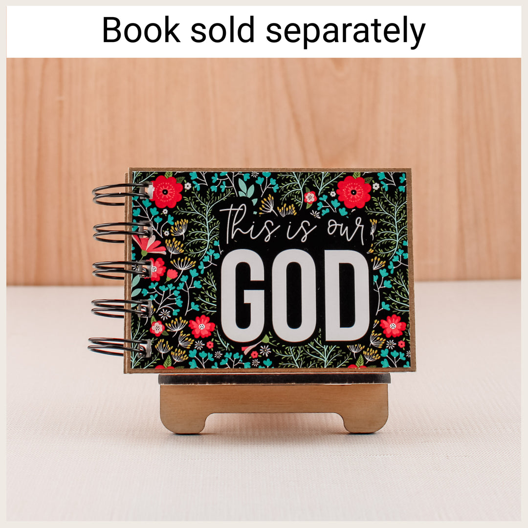 Wood easel displaying a floral This Is Our God attributes book. Book sold separately.
